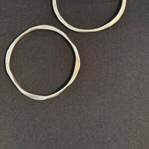Pair of freeform shaped silver bracelets